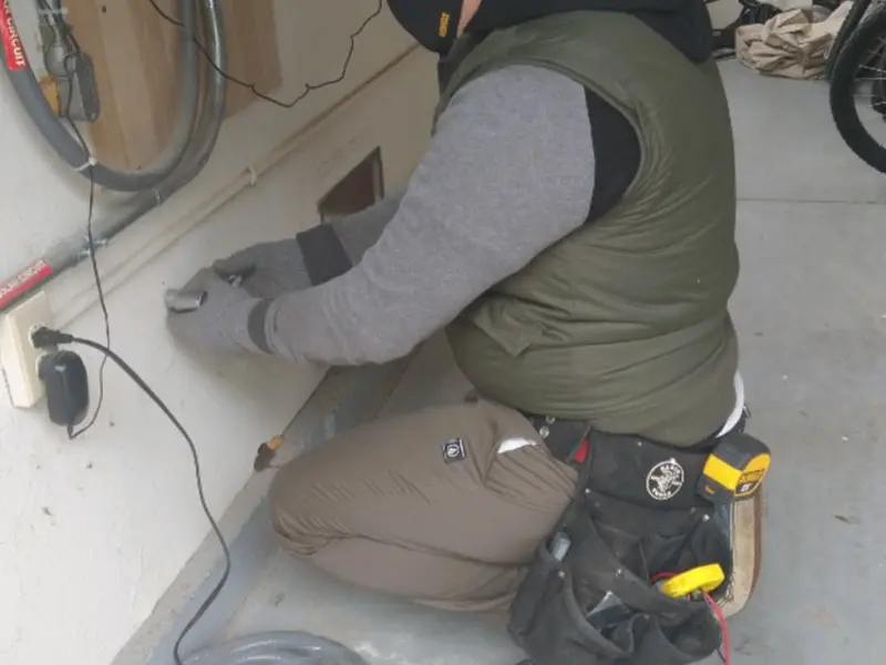 Electrician performing outlet wiring in a Ely garage